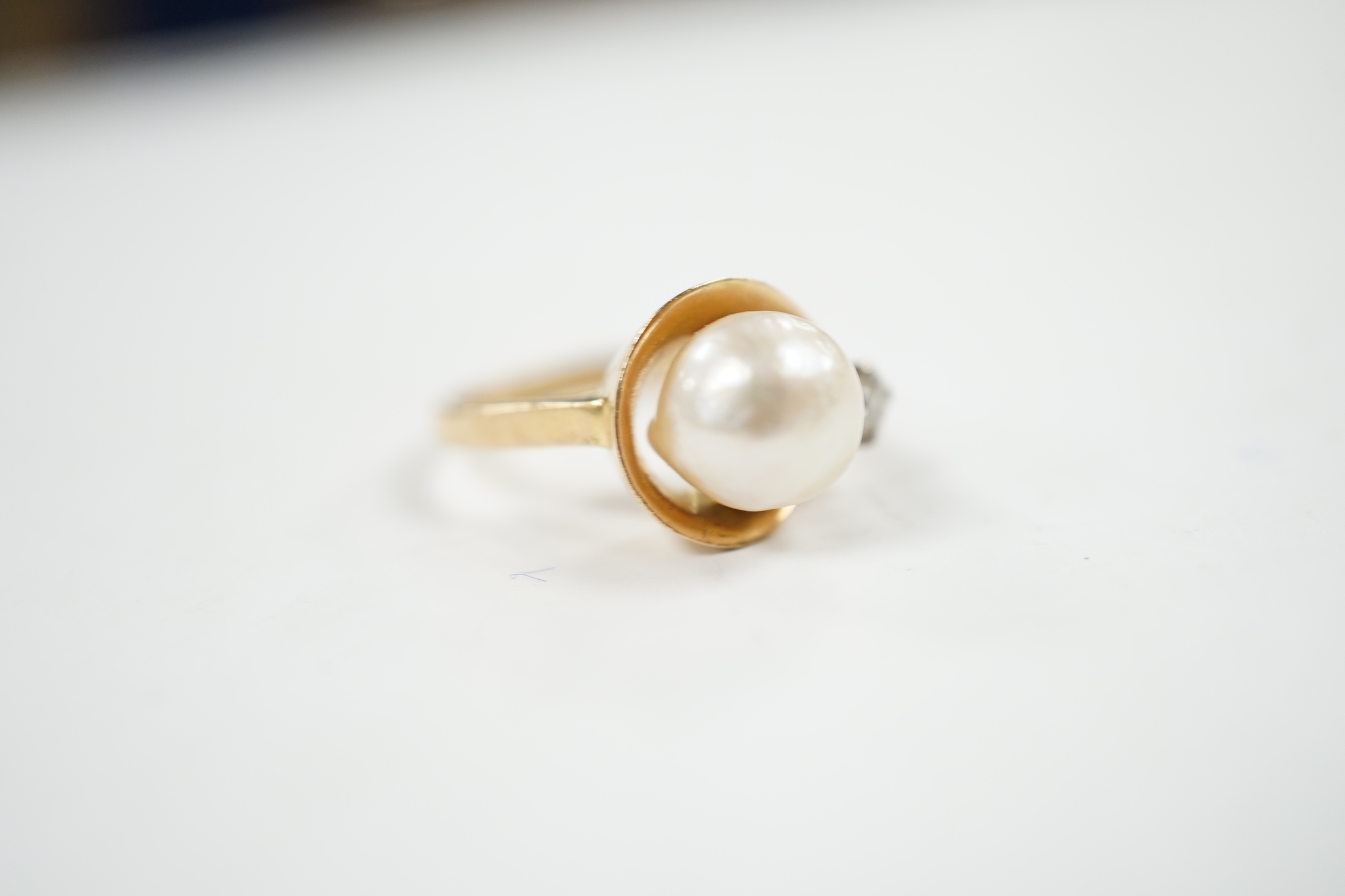 A yellow metal , single stone cultured pearl and single stone diamond set ring, size J, gross weight 4.8 grams.